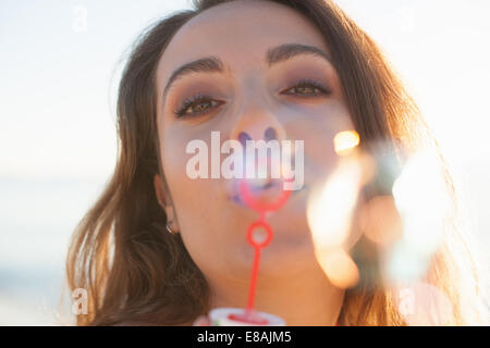 Close up of young woman blowing bubbles sur plage, Castiadas, Sardaigne, Italie Banque D'Images