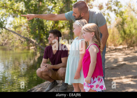 Homme couple à la recherche d'une rivière avec deux filles Banque D'Images