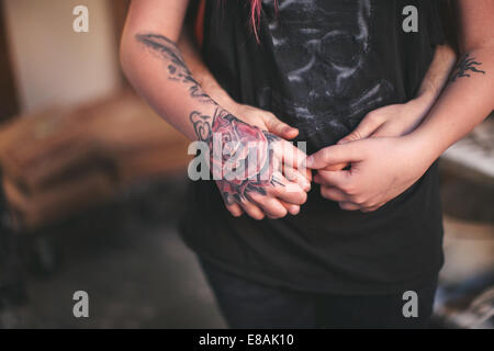 Tattooed hand holding personne derrière Banque D'Images