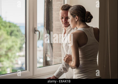 Jeune couple chatting et à la recherche de salon windows Banque D'Images