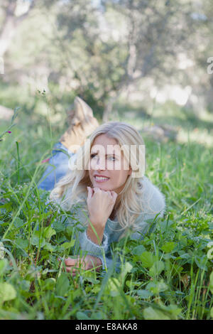 Woman lying on grass in garden Banque D'Images