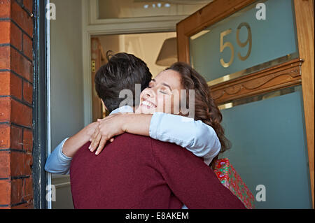 Couple hugging at front door Banque D'Images