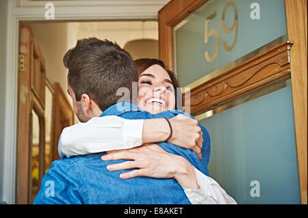 Couple hugging at front door Banque D'Images