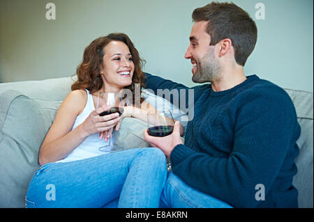 Couple enjoying wine sur canapé Banque D'Images