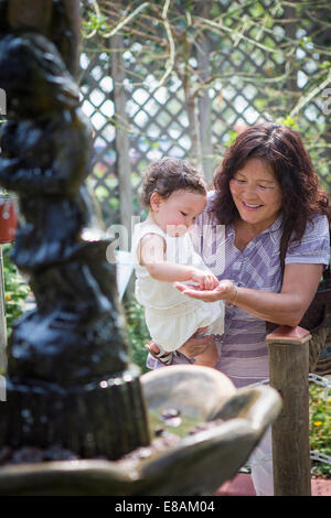 Grand-mère et sa petite-fille s'alimentant à l'étang au zoo Banque D'Images