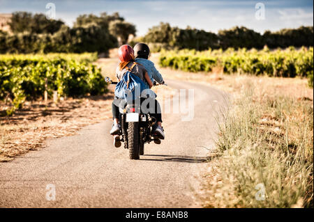 Vue arrière du couple riding sur la liquidation chemin rural, Cagliari, Sardaigne, Italie Banque D'Images