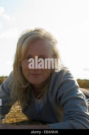 Woman lying on field Banque D'Images