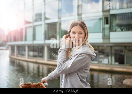 Woman pushing bike le long de canal, East London, UK Banque D'Images