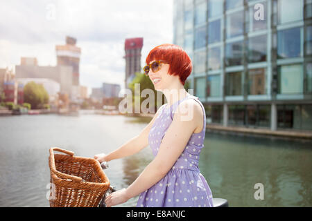 Woman pushing bike le long de canal, East London, UK Banque D'Images