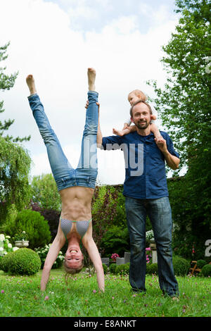 Mère doing handstand in jardin près de famille Banque D'Images