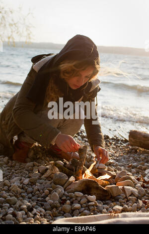 Femme faisant un feu en mer Banque D'Images