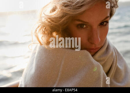 Femme tout enveloppé sur plage de vent Banque D'Images