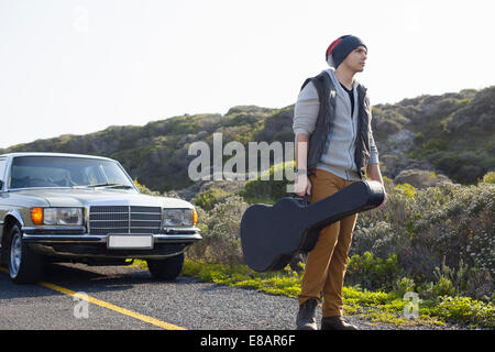 Jeune homme sur la route avec étui à guitare, Cape Town, Western Cape, Afrique du Sud Banque D'Images