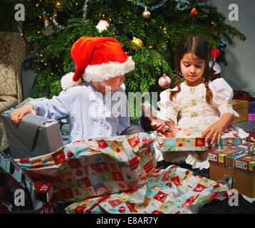 Les enfants d'ouvrir les cadeaux de Noël Banque D'Images