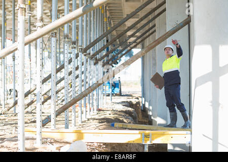 Site manager d'atteindre à la vérification du travail on construction site Banque D'Images