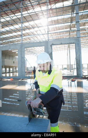 Builder à l'aide de scie tournante on construction site Banque D'Images