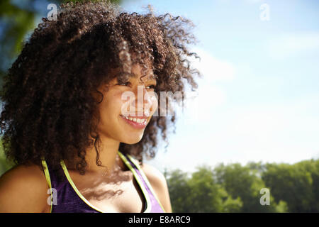 Smiling young woman in park Banque D'Images