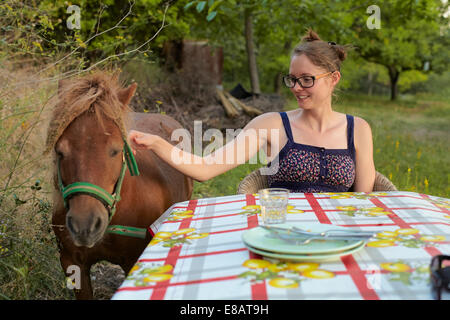 Jeune femme à la table ferme pédagogique poney, Sierra Nevada, Grenade, Andalousie Espagne Banque D'Images