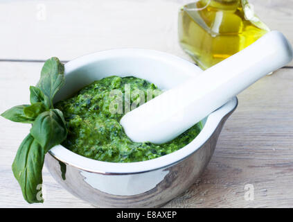 Pesto de basilic dans un bol en céramique sur fond de bois Banque D'Images