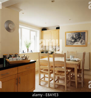 Table et chaises en bois peint en crème pays cuisine salle à manger avec noir +blanc sur le mur Banque D'Images