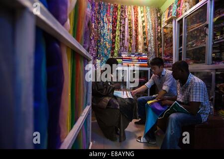 Dakar, Sénégal. 16 Sep, 2014. Un vendeur chinois (C) parle à un employé d'un magasin local à Touba, la ville sainte du Sénégal, le 16 septembre 2014. L'activité de vendeurs locaux chinois commence à la flèche un mois avant l'Aïd al-Adha, connue comme la Tabaski dans la langue locale de Wolof, comme sénégalais se préparer pour le festival le plus important de l'année sur 5 oct. © Li Jing/Xinhua/Alamy Live News Banque D'Images