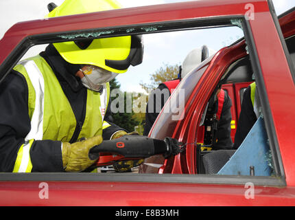 Officier pompier couper loin un toit de voiture chez car smash Banque D'Images