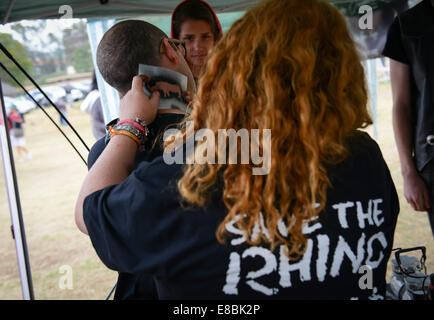 Pretoria, Afrique du Sud. 4ème Oct, 2014. Une fille tatouages le cou de son ami avec un rhino avant la marche pour l'éléphant, rhinocéros et Lion à Pretoria. Pour marquer la Journée mondiale des animaux, l'éléphant, rhinocéros pour mars et Lion est détenu par le Département des affaires environnementales d'Afrique du Sud et les organisations de protection de l'environnement local ici samedi. Près de 1 000 personnes ont pris part à l'événement à Pretoria, qui est l'un des plus de 130 marches en prenant place dans le monde le 4 octobre 2014 pour protester contre le braconnage d'éléphants et de rhinocéros et de lions en conserve la chasse. Source : Xinhua/Alamy Live News Banque D'Images