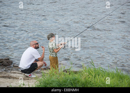 Garçon de pêche avec son père sur la rive de la Vistule à Varsovie, Pologne Banque D'Images