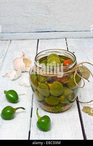 Un pot avec piments fraîchement cueillis conservés dans le vinaigre, sur une table en bois rustique Banque D'Images