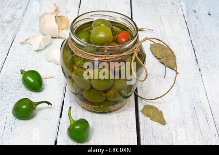 Un pot avec piments fraîchement cueillis conservés dans le vinaigre, sur une table en bois rustique Banque D'Images