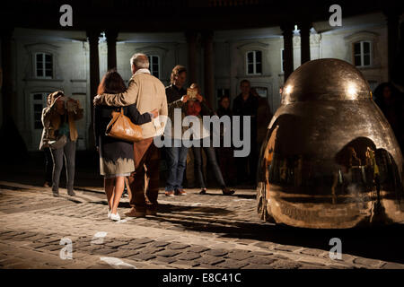 Paris, France. 4ème Oct, 2014. Un couple pose pour une photo devant une grosse cloche de bronze réalisés par l'artiste Pierre Charpin. Nuit Blanche, Paris, France. Le 4 octobre 2014. Crédit : Rachel Applefield/Alamy Live News Banque D'Images