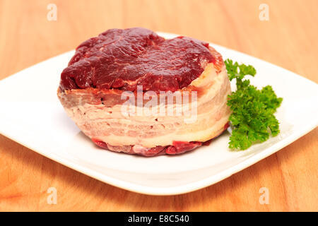 Filet mignon 8 oz deux steaks de bœuf enveloppé de bacon sur une planche à découper en bois. Banque D'Images