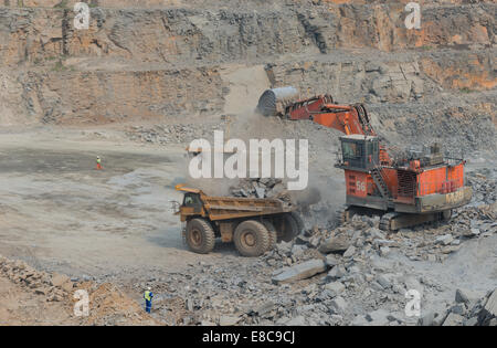 Hitatchi charges excavatrice Caterpillar camions minerai sur l'exploitation minière à ciel ouvert dans une grande mine de cuivre d'Afrique alors que le superviseur observe Banque D'Images