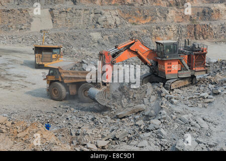 Hitatchi charges excavatrice Caterpillar camions minerai sur l'exploitation minière à ciel ouvert dans une grande mine de cuivre d'Afrique alors que le superviseur observe Banque D'Images