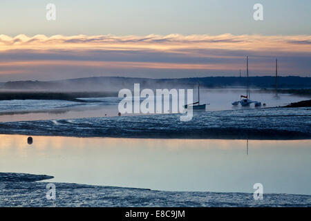 Oare près de Faversham, Kent, UK, 5 octobre 2014. Météo : un lever de soleil à froid et brumeux Oare Creek comme le temps tourne vers l'automne et les conditions plus froides sont prévues pour la semaine à venir. Banque D'Images