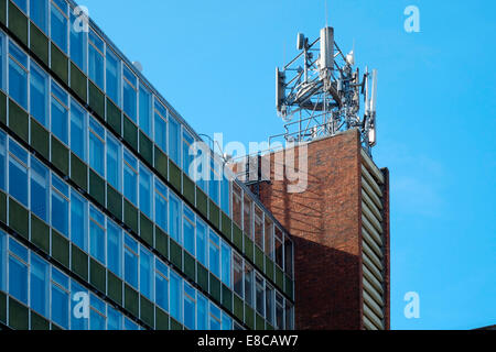 Téléphone mobile et l'équipement de télécommunications monté sur le haut d'un immeuble du centre-ville angleterre uk Banque D'Images