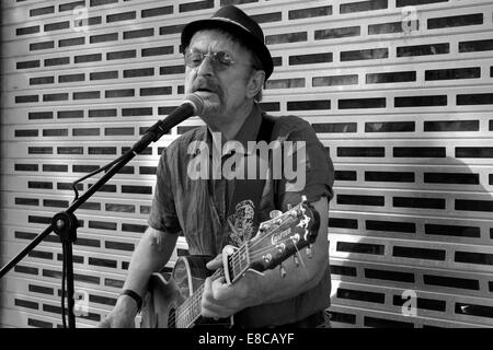 Mâle mature musicien ambulant avec guitare chanter dans un centre-ville angleterre uk Banque D'Images