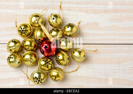 High angle shot d'un groupe de Noël Jingle bells sur une table en bois blanc. Format horizontal avec un rouge entouré d'une bell Banque D'Images