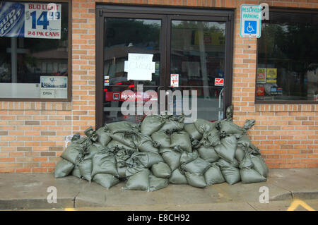 Cette photographie montre des sacs de sable placés autour d'une station-service à Cedar Rapids, dans l'Iowa. Les sacs de sable sont couramment utilisés dans les efforts de prévention des inondations pour protéger les bâtiments et les infrastructures contre les dommages causés par les eaux lors de fortes pluies ou d'inondations. L'image met l'accent sur les mesures locales de préparation à la gestion des inondations dans la région. Banque D'Images