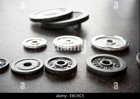 Collection de disques d'haltère organisées sur sol noir en bref dept de champ Banque D'Images