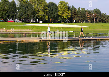 L'homme et de la femme, après l'usure de l'aviron, bateau sur la rive du lac Banque D'Images