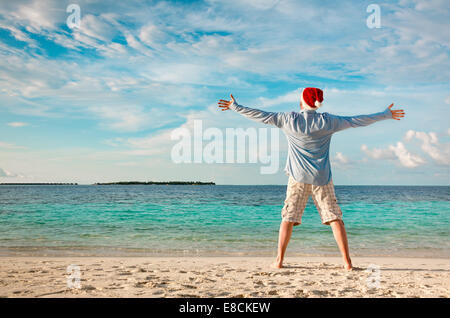 Vacances de Noël - homme à Santa hat sur la plage tropicale Banque D'Images