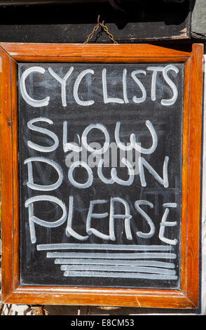 Les cyclistes Ralentir Veuillez ouvrir hawkshead, Lake District, Cumbria Banque D'Images