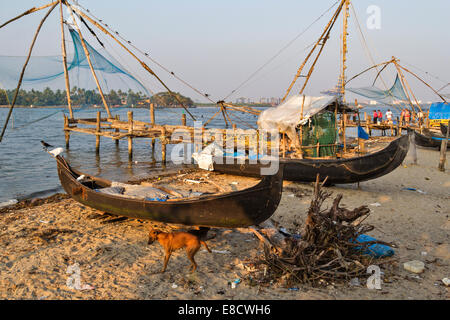 Les bateaux traditionnels ou des CANOTS SUR LA PLAGE AVEC DES FILETS CHINOIS KOCHI INDE Banque D'Images