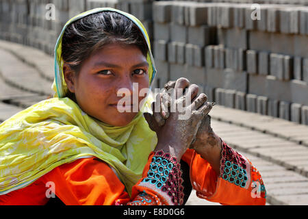 Brickyard femelle travailleur (14 ans) forment les briques sur un champ de l'Patoki briqueterie près de Lahore, Pakistan Banque D'Images