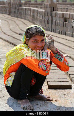 Brickyard femelle travailleur (14 ans) forment les briques sur un champ de l'Patoki briqueterie près de Lahore, Pakistan Banque D'Images