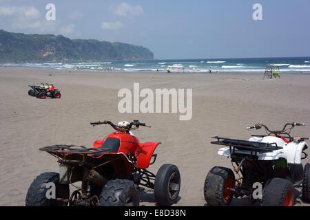 Quad en ligne sur une plage quasi déserte Indonesian prêt et en attente de l'arrivée des touristes. Banque D'Images