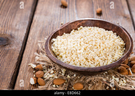 Petit bol avec les amandes hachées (close-up shot) sur fond de bois rustique Banque D'Images