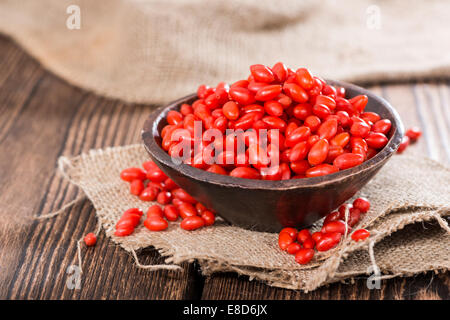 Quelques baies de Goji frais (également connu sous le nom de Wolfberry) vintage sur fond de bois Banque D'Images