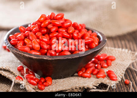 Quelques baies de Goji frais (également connu sous le nom de Wolfberry) vintage sur fond de bois Banque D'Images